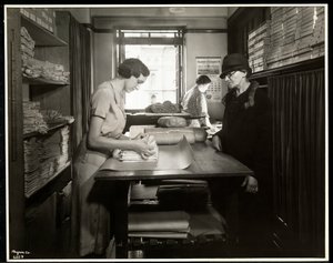 Giovane donna che avvolge materiali di stoffa per una lavoratrice a domicilio, presso la New York Association for the Blind, 111 East 59th Street, New York, 1931